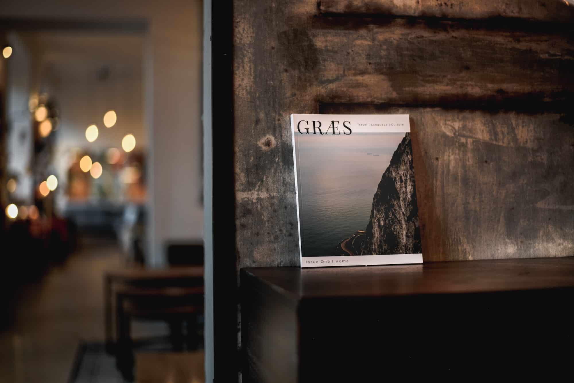 Aufgeschlagenes Magazin auf rohem Beton – Lesestoff aus der Agentur